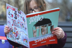 Kind liest Kindermagazin "echt jetzt?" zu den Themen Optik und dem menschlichen Sehen